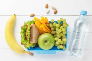 student study desk with books water and healthy snacks