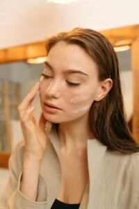 Woman applying facial moisturizer as part of a daily skin care routine